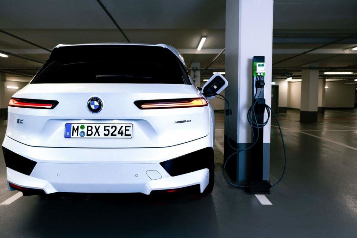 BMW iX se recharge dans un parking